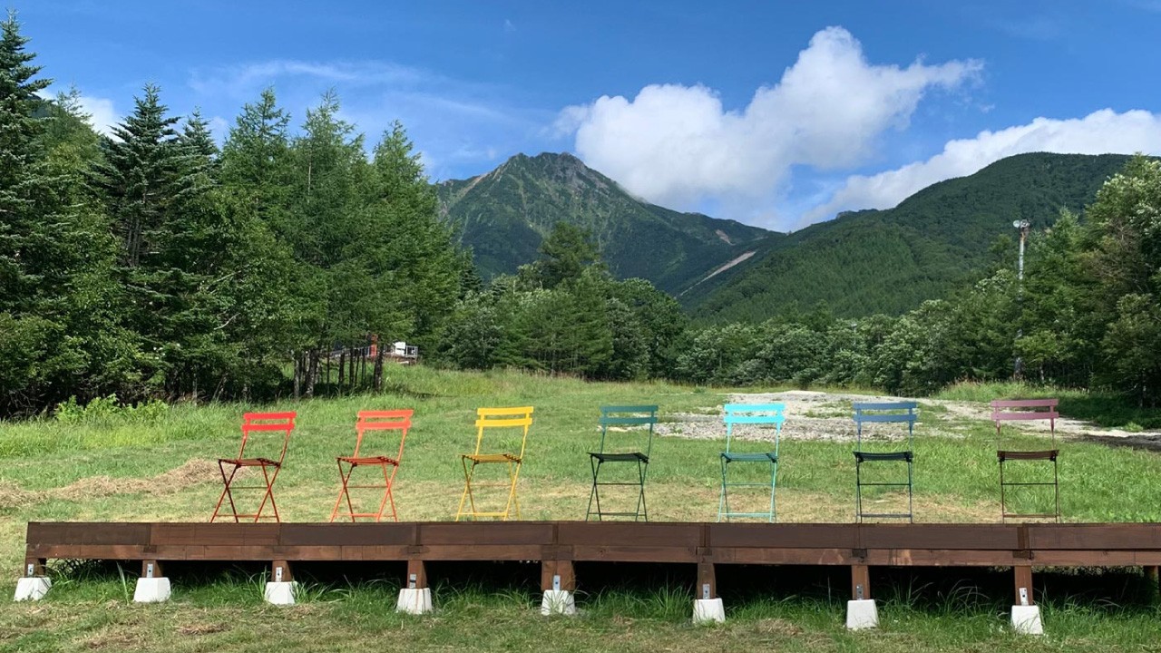 カラフルな椅子が並べられた、緑の中で自由気ままに過ごしていただくためのコンセプトエリア。